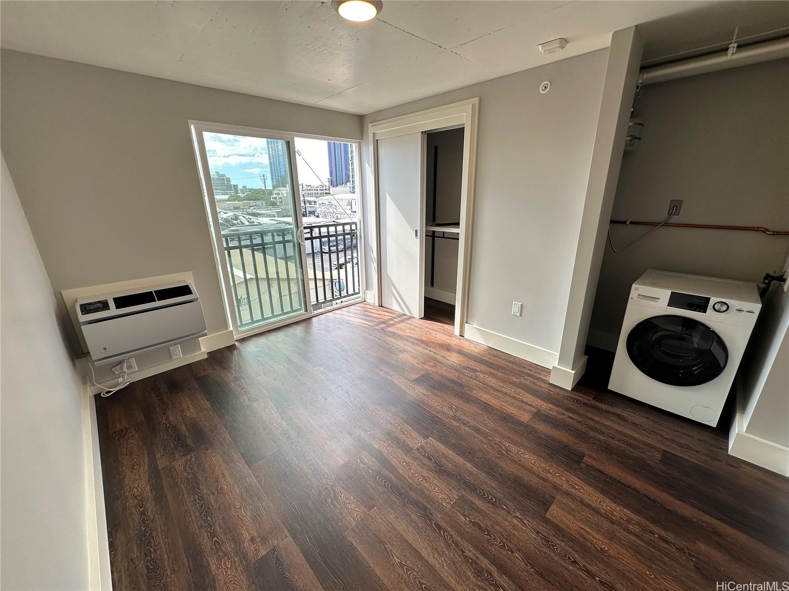 a view of a hallway with wooden floor and cabinets