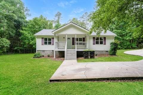 a front view of a house with a yard and trees