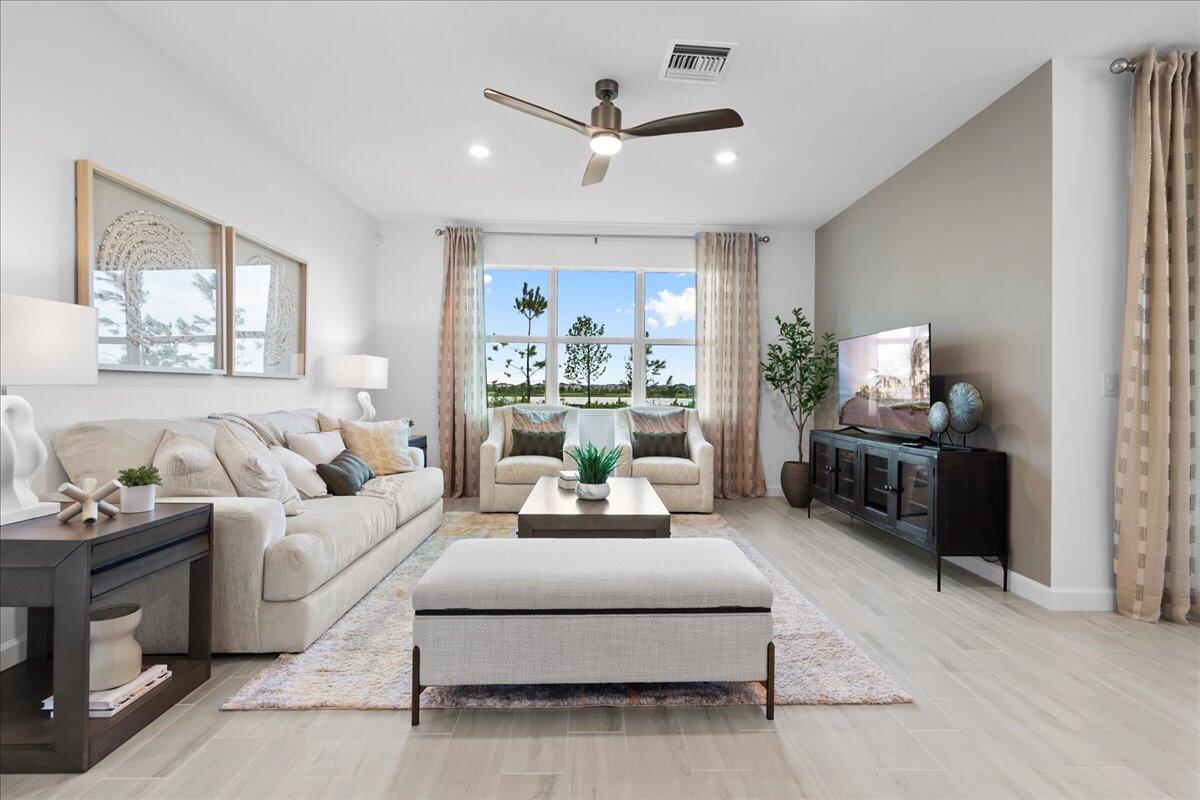 a living room with furniture a large window and a chandelier