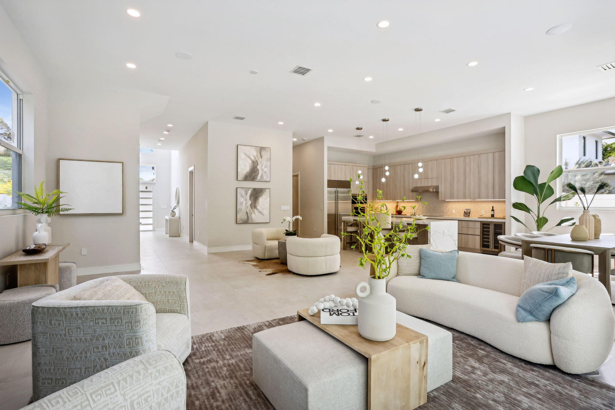 a living room with furniture kitchen view and large windows