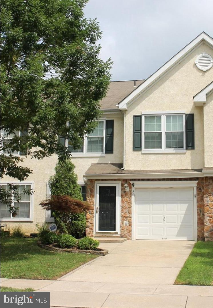 a front view of a house with yard and parking