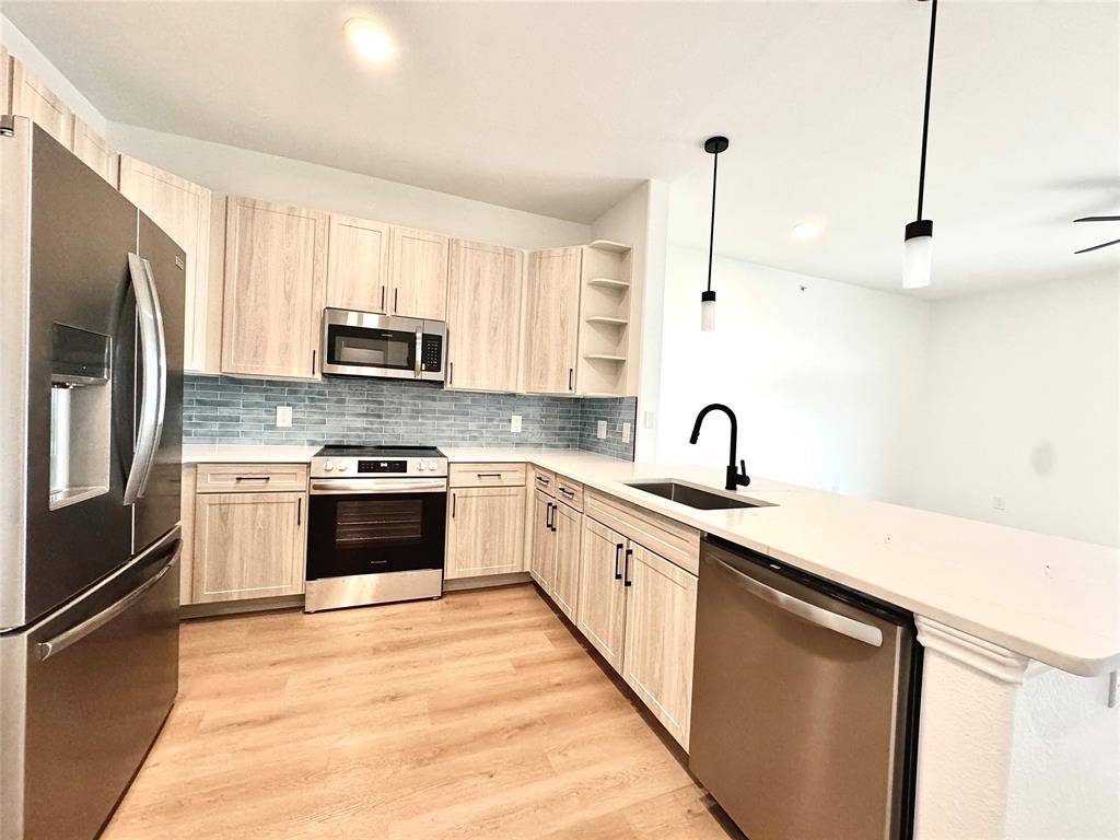 a kitchen with stainless steel appliances granite countertop a sink stove and refrigerator