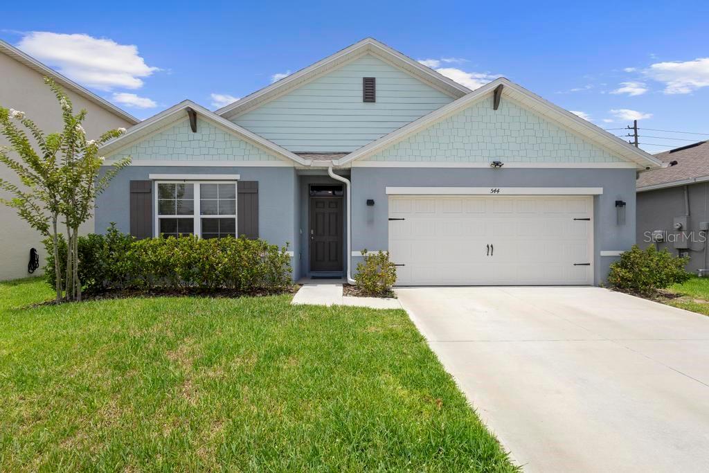 a front view of a house with a yard and garage