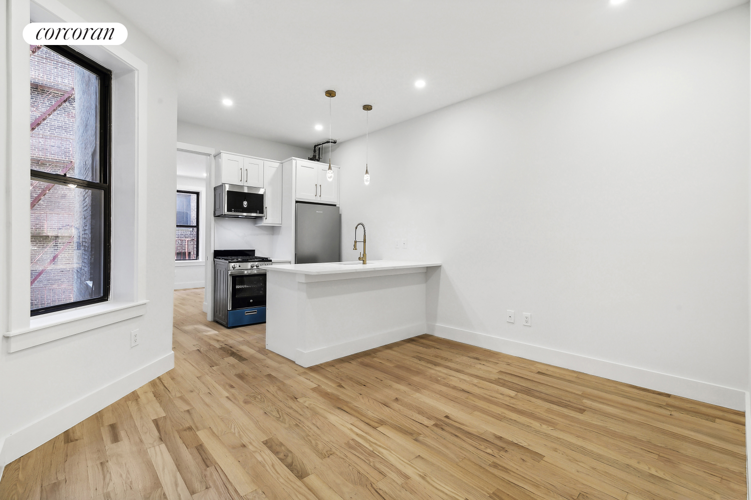 a view of a kitchen with wooden floor and electronic appliances