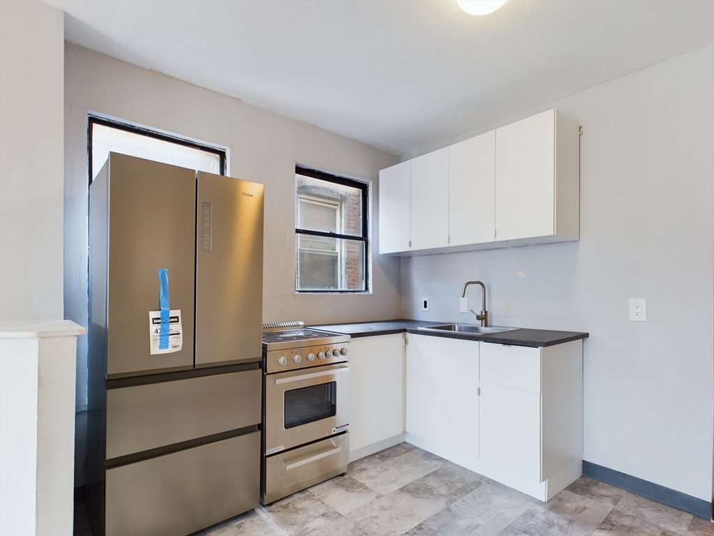 a kitchen with white cabinets and white appliances