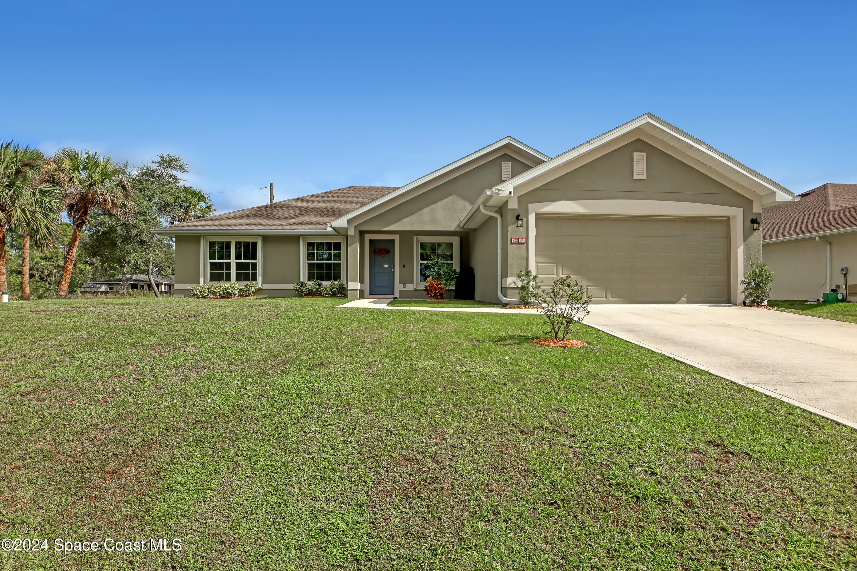 a front view of a house with a yard and trees