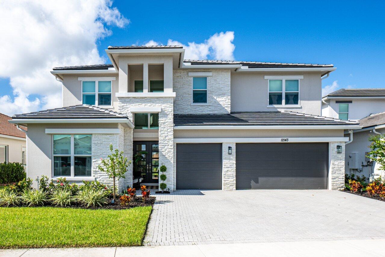 a front view of a house with a yard and garage