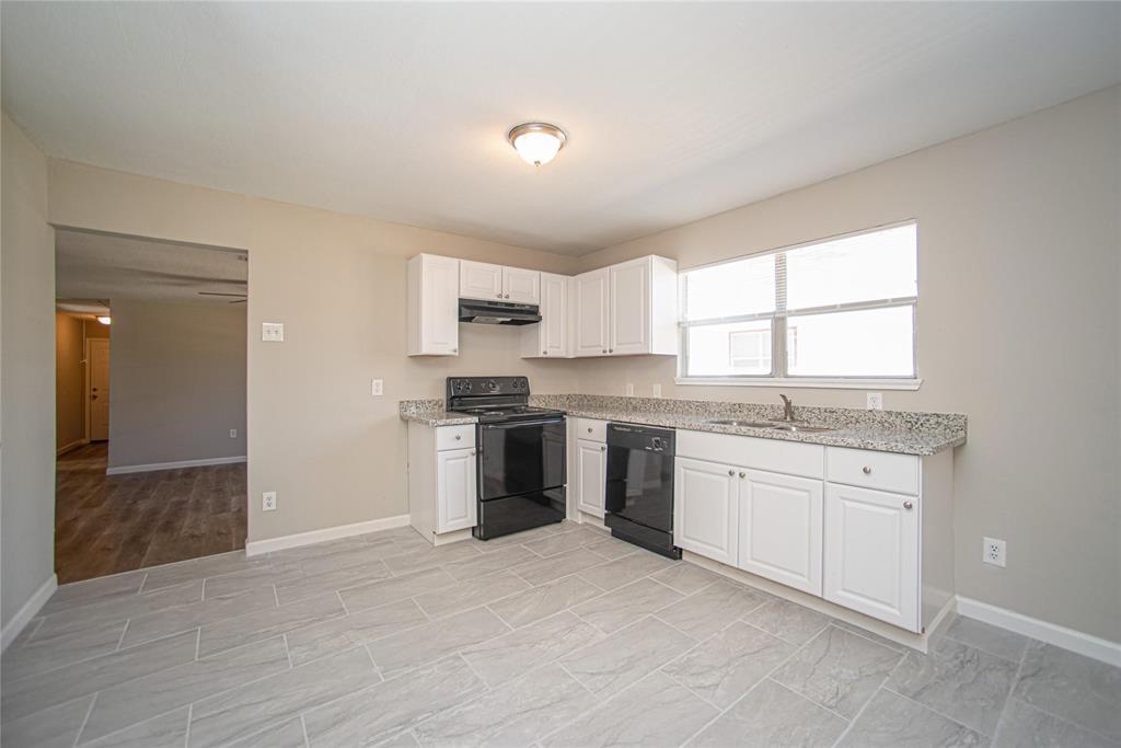 a kitchen with granite countertop a sink stove and refrigerator