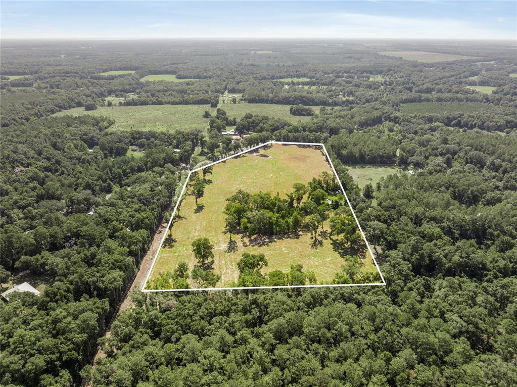 an aerial view of residential houses with outdoor space and trees