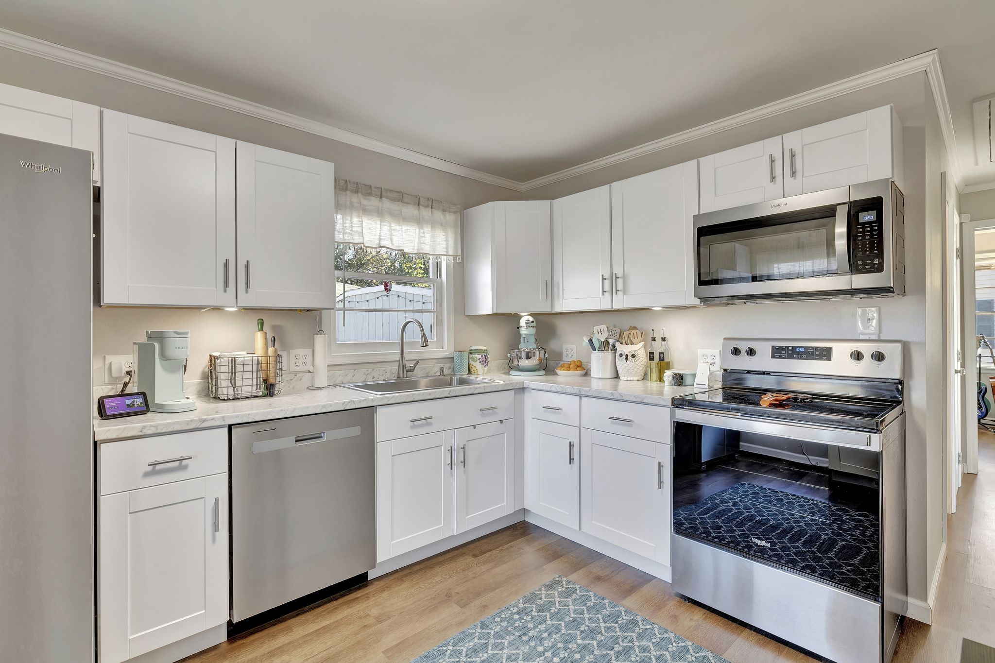 a kitchen with cabinets stainless steel appliances and a window