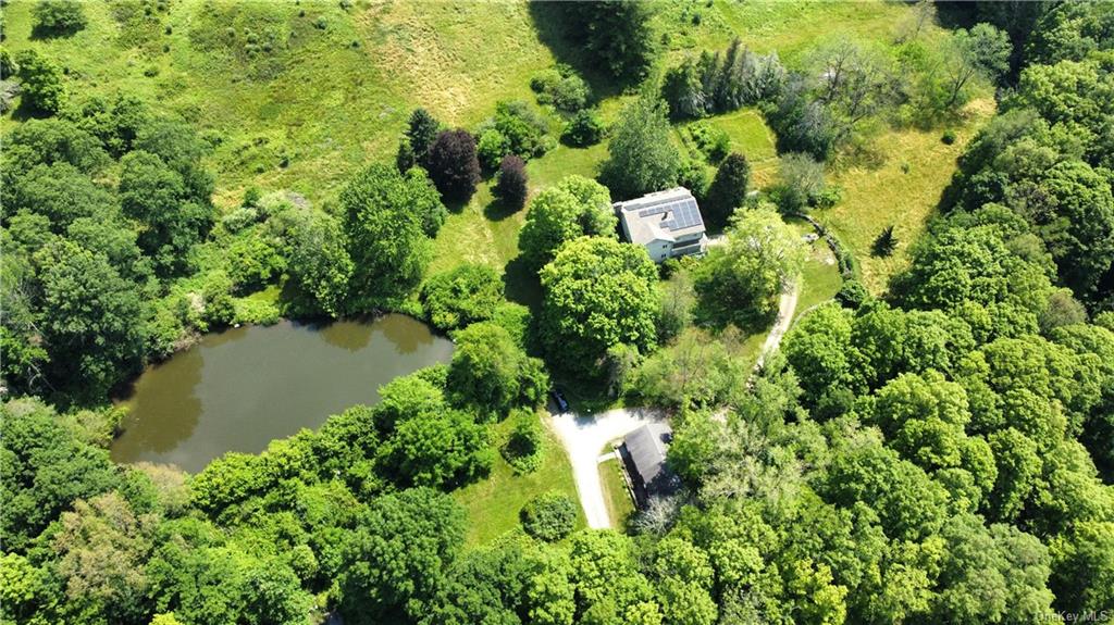 an aerial view of residential house with outdoor space and trees all around