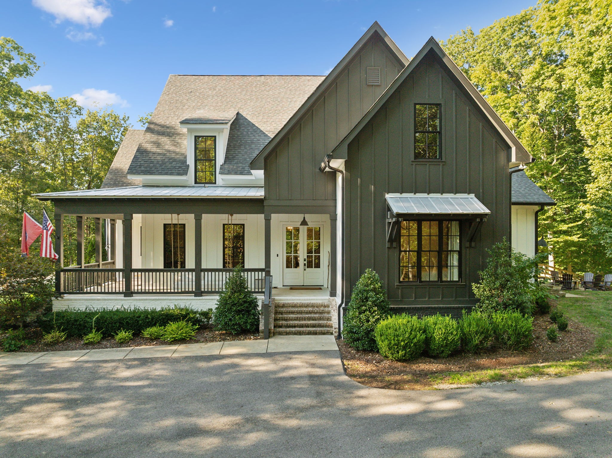 a front view of a house with a yard and potted plants