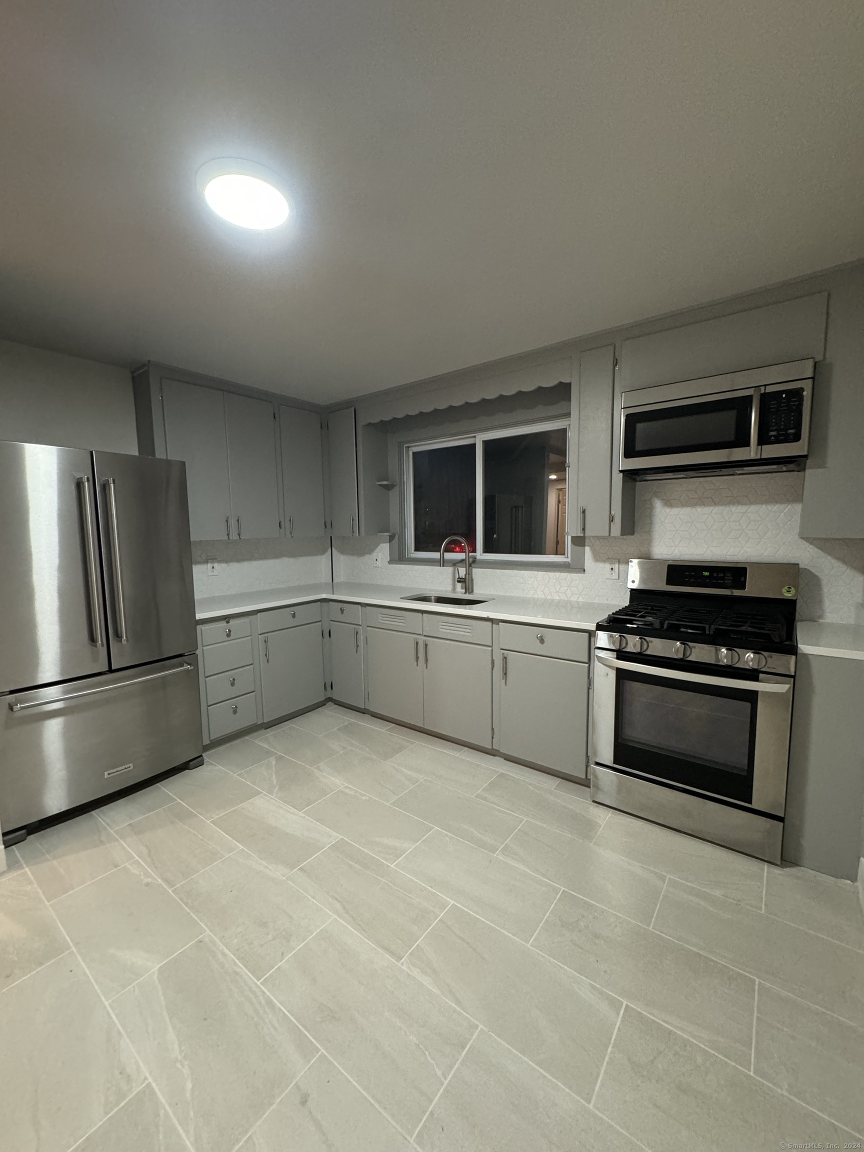 a kitchen with stainless steel appliances a refrigerator a sink a stove and cabinets