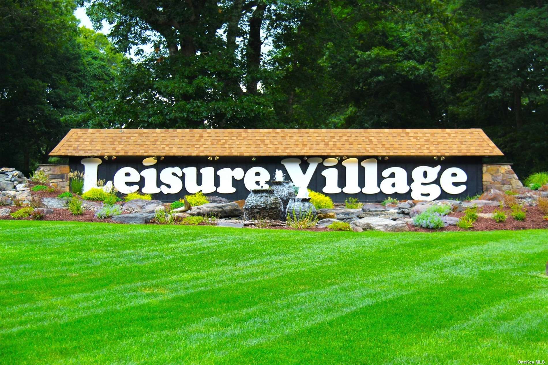 a sign that is sitting in front of a house with garden