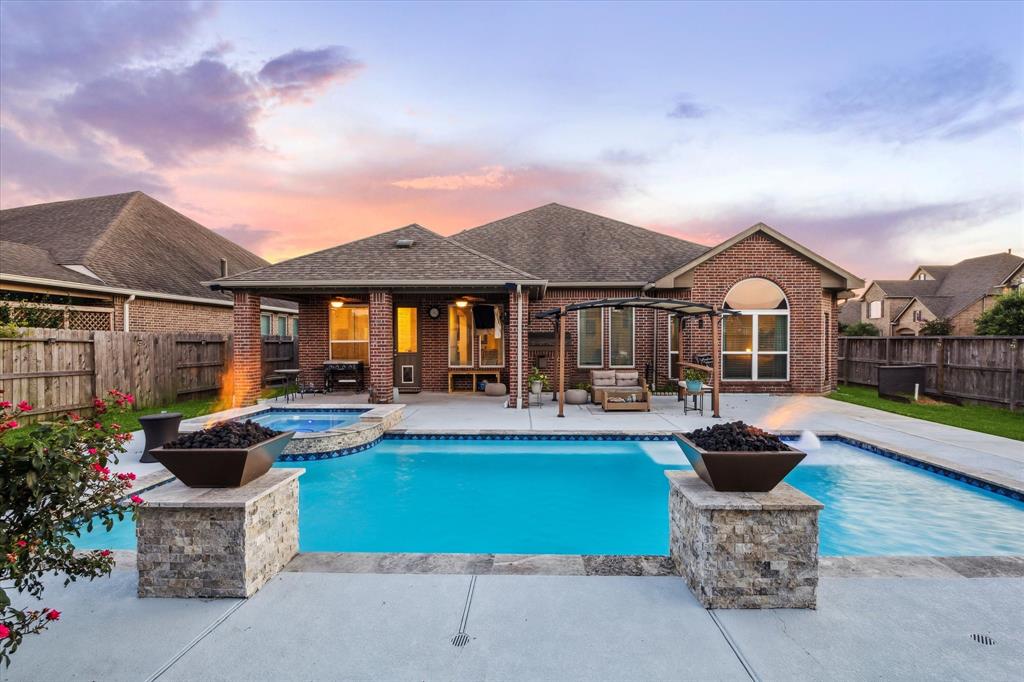 a front view of a house with swimming pool and a fire pit