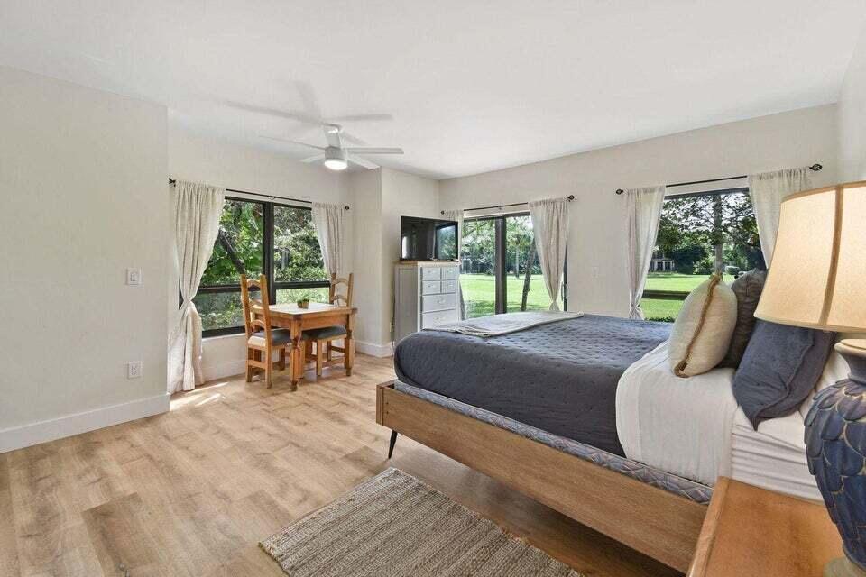 a bedroom with a bed a table and large window with outer view