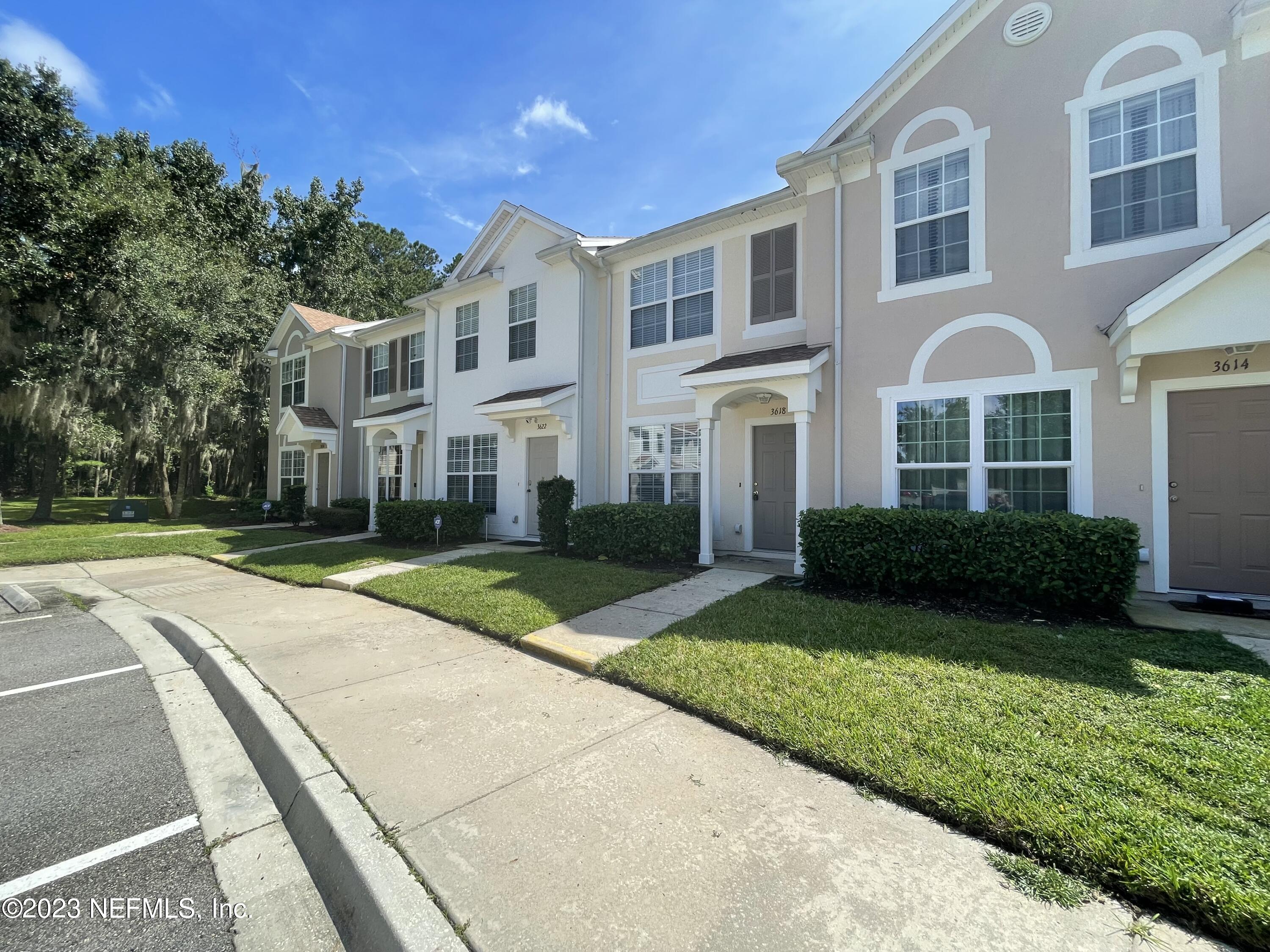 a front view of a house with yard and green space