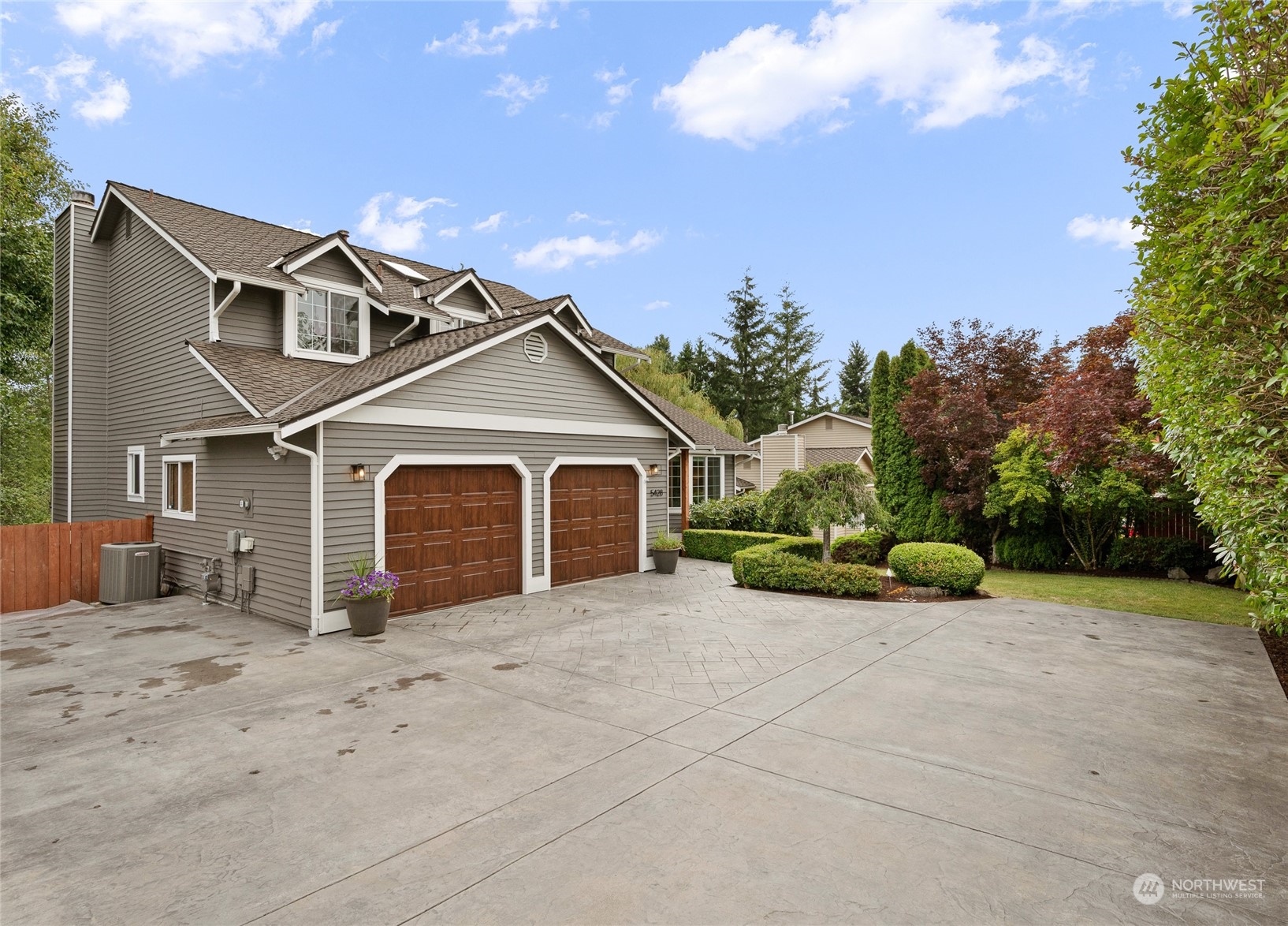 a view of a house with a yard and large tree