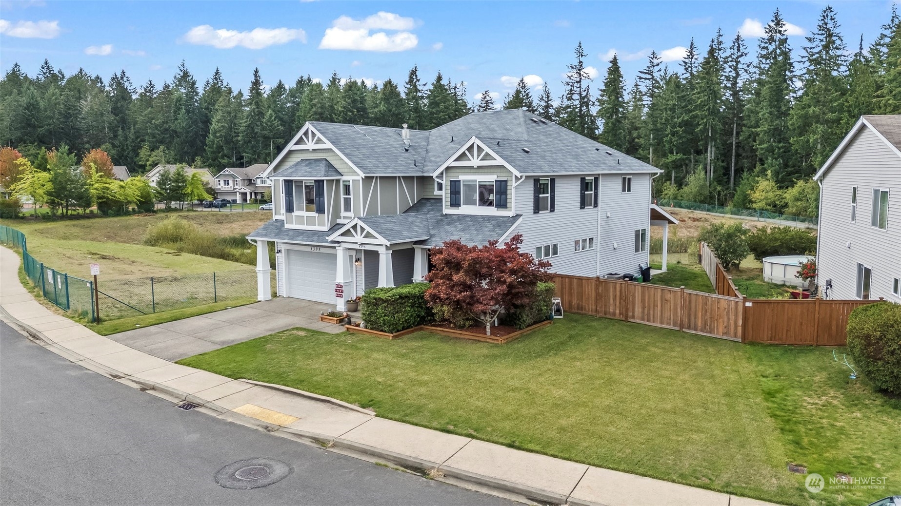 a aerial view of a house next to a big yard and large trees