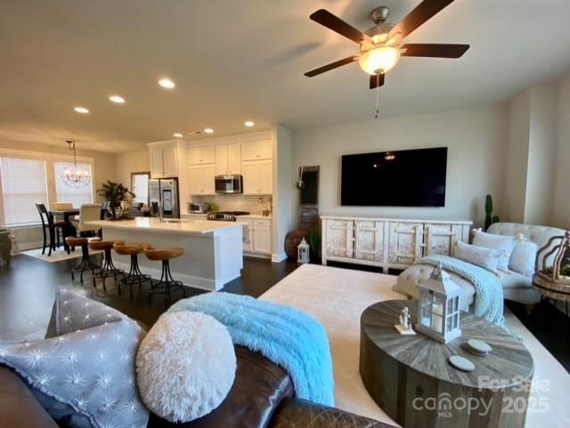 a living room with furniture kitchen view and a flat screen tv