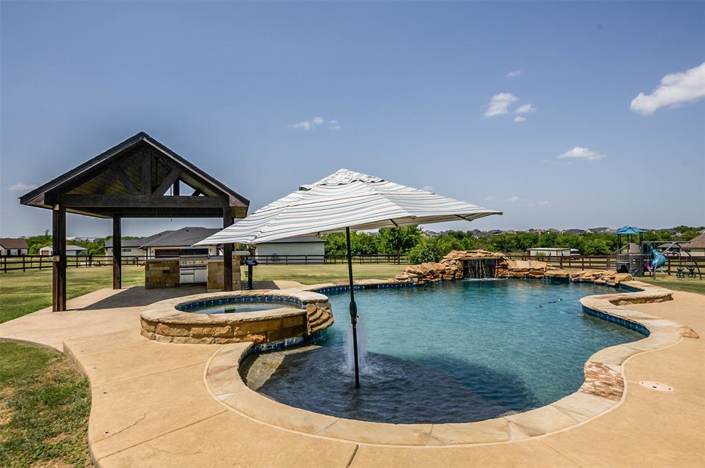 a roof deck with table and chairs under an umbrella