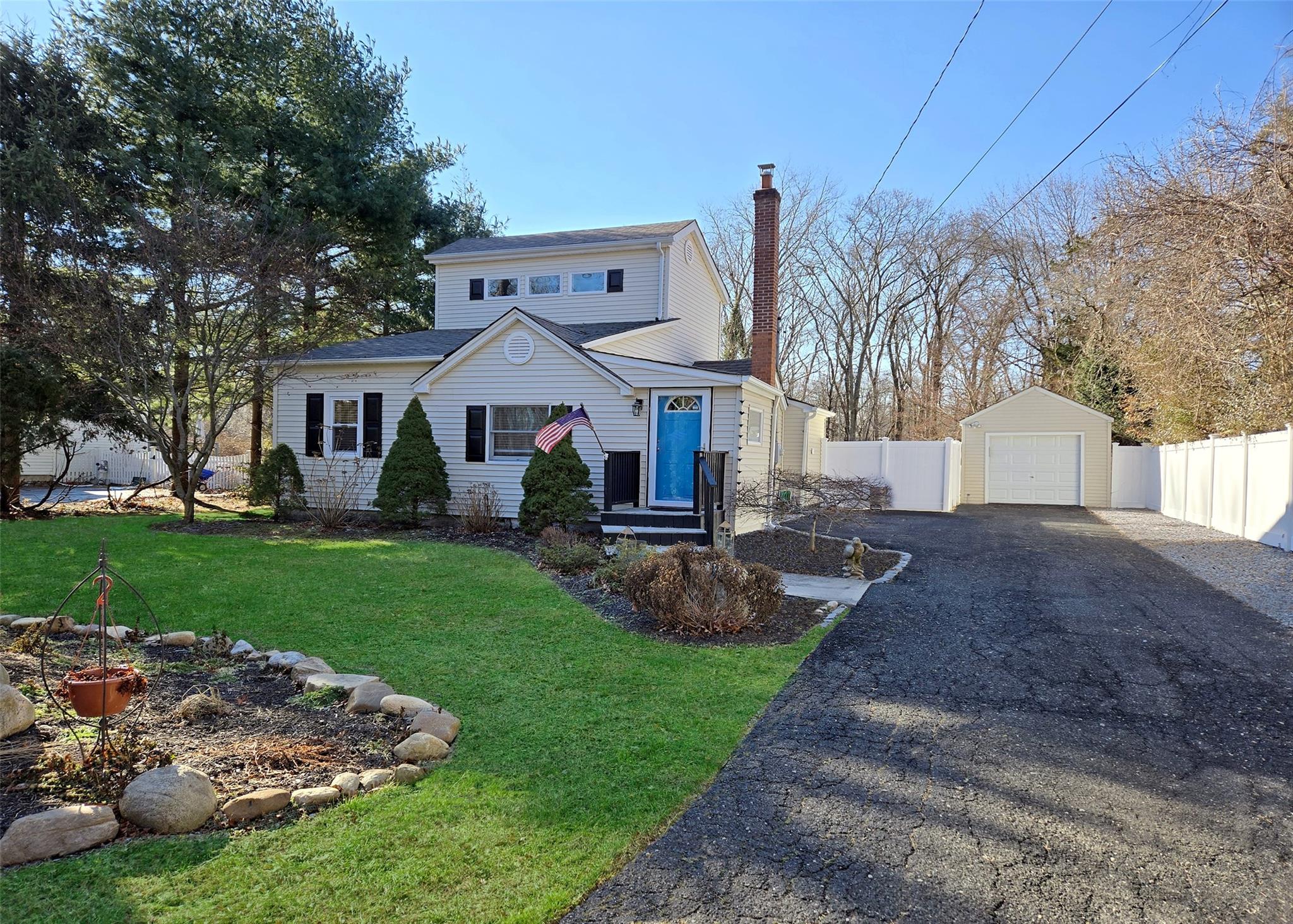 View of property featuring a garage, a front lawn