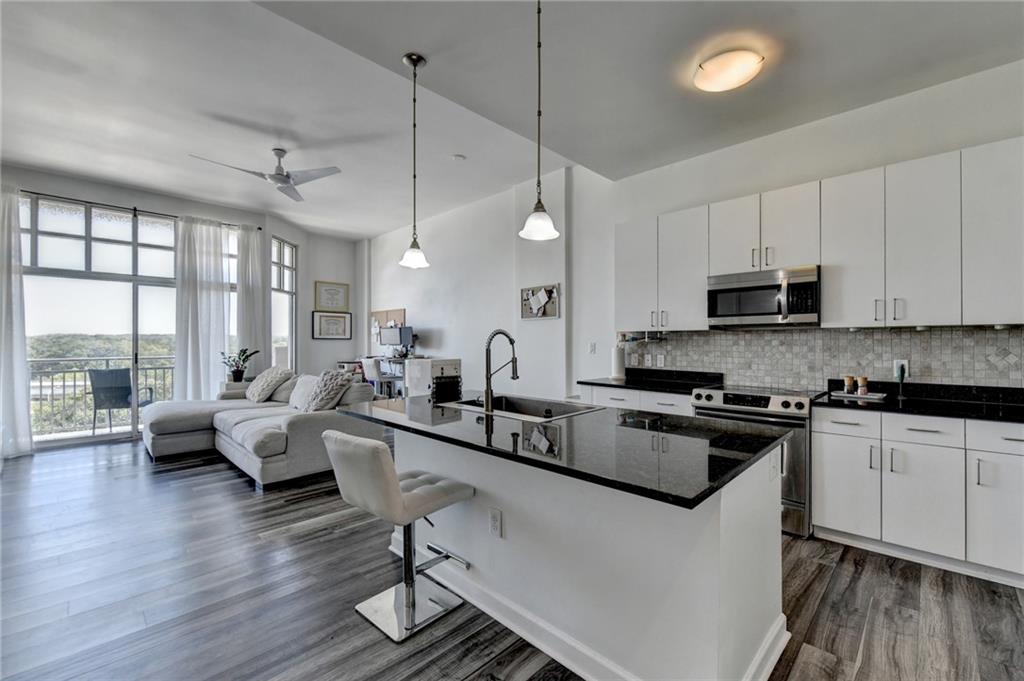 a kitchen with white cabinets and black stainless steel appliances