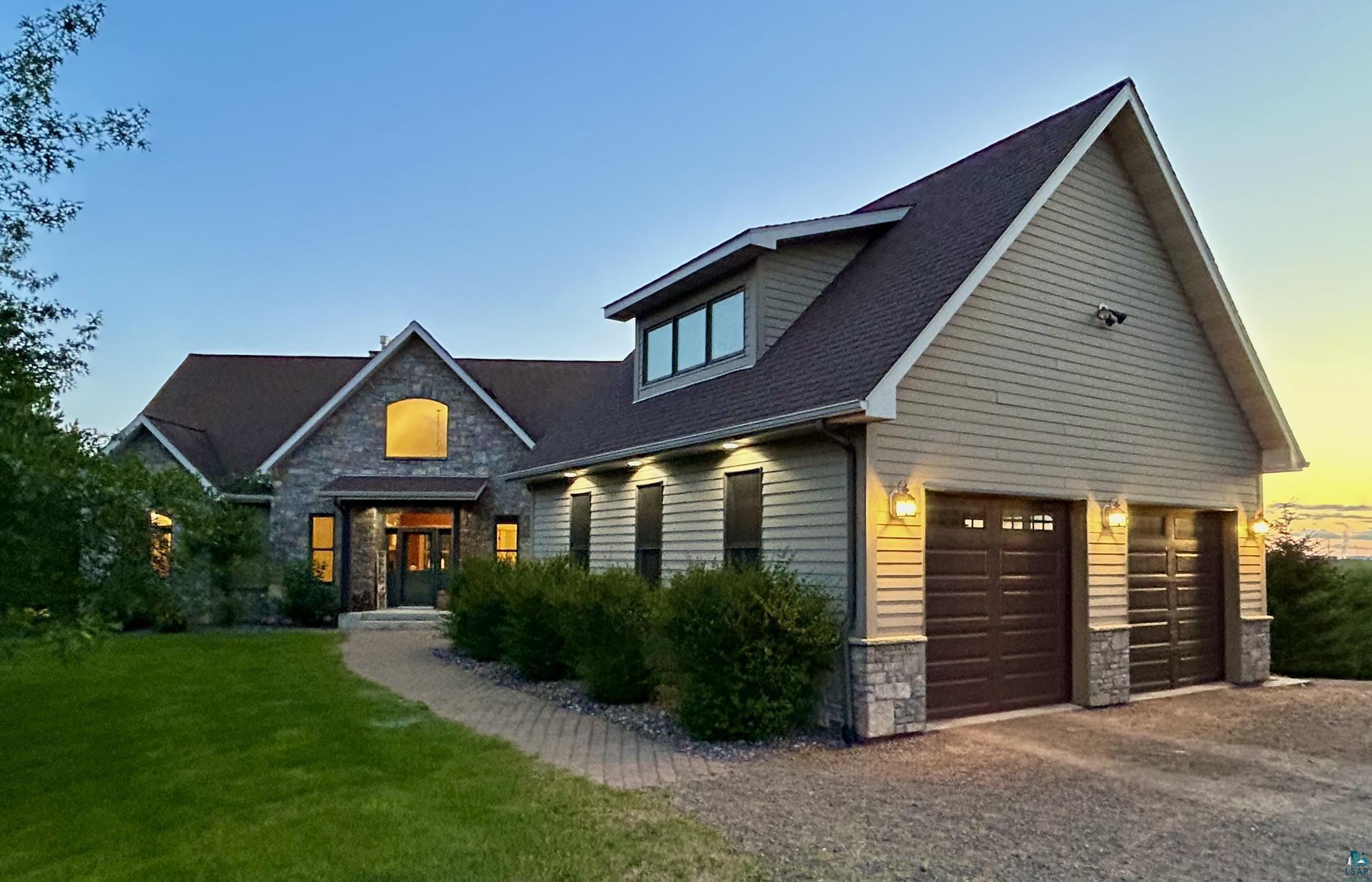 View of front facade with a garage and a lawn