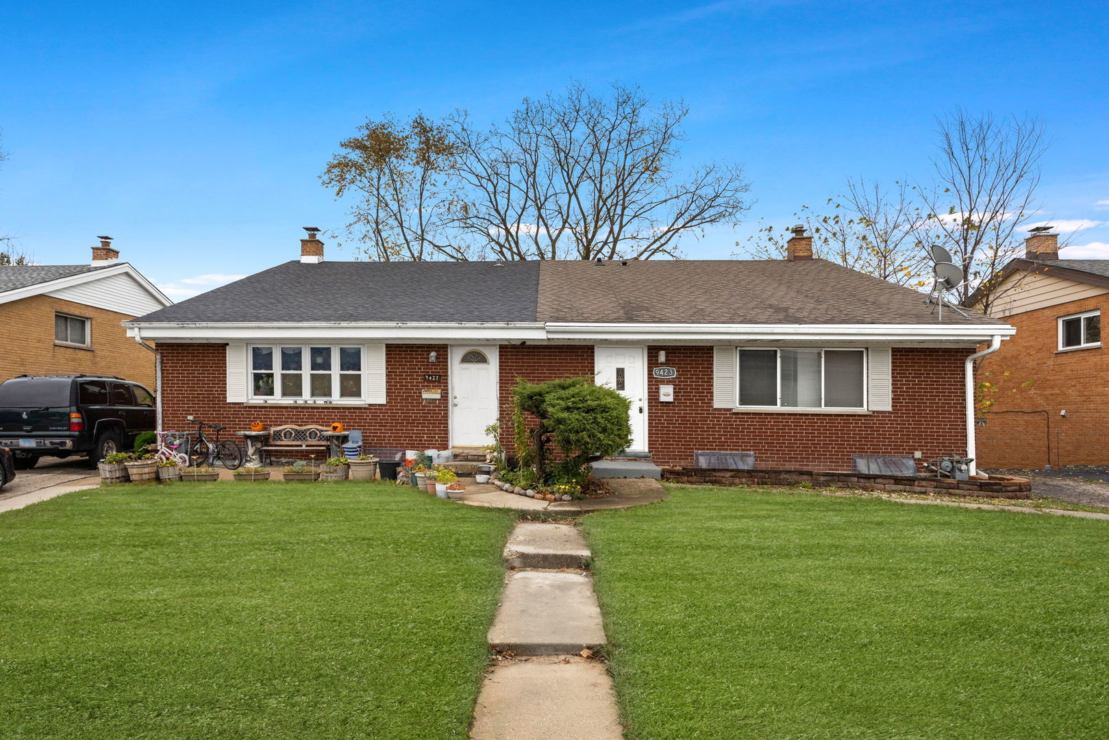 a front view of a house with a yard and trees