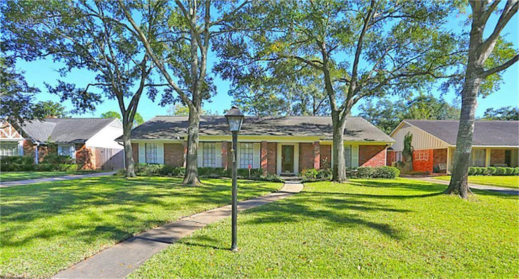 a front view of a house with a yard and trees