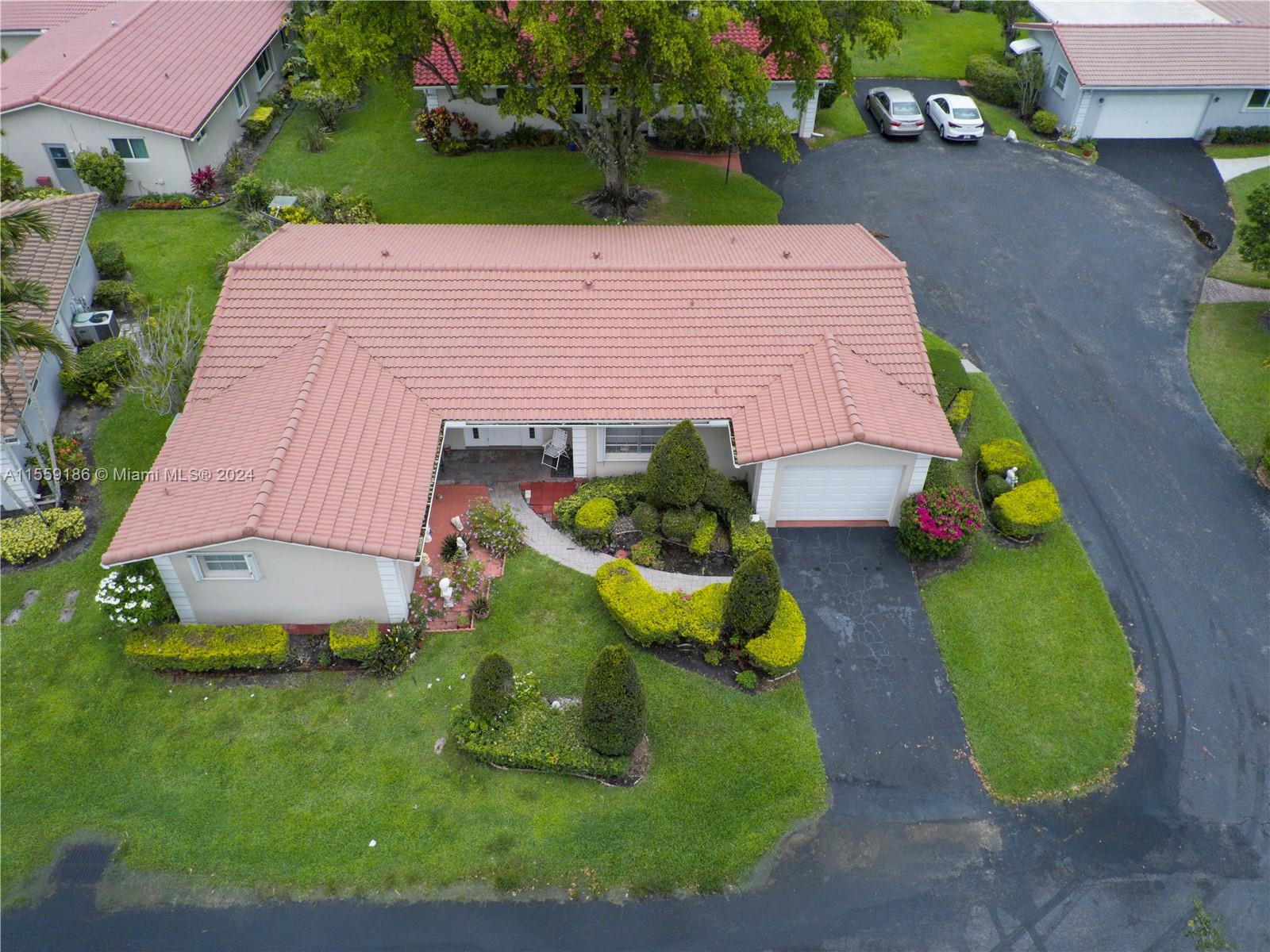 a aerial view of a house with a yard and potted plants