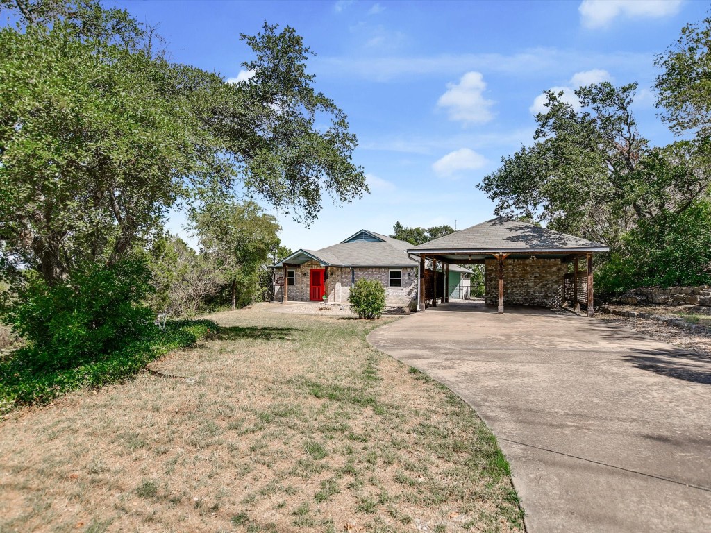 a front view of a house with a yard and trees