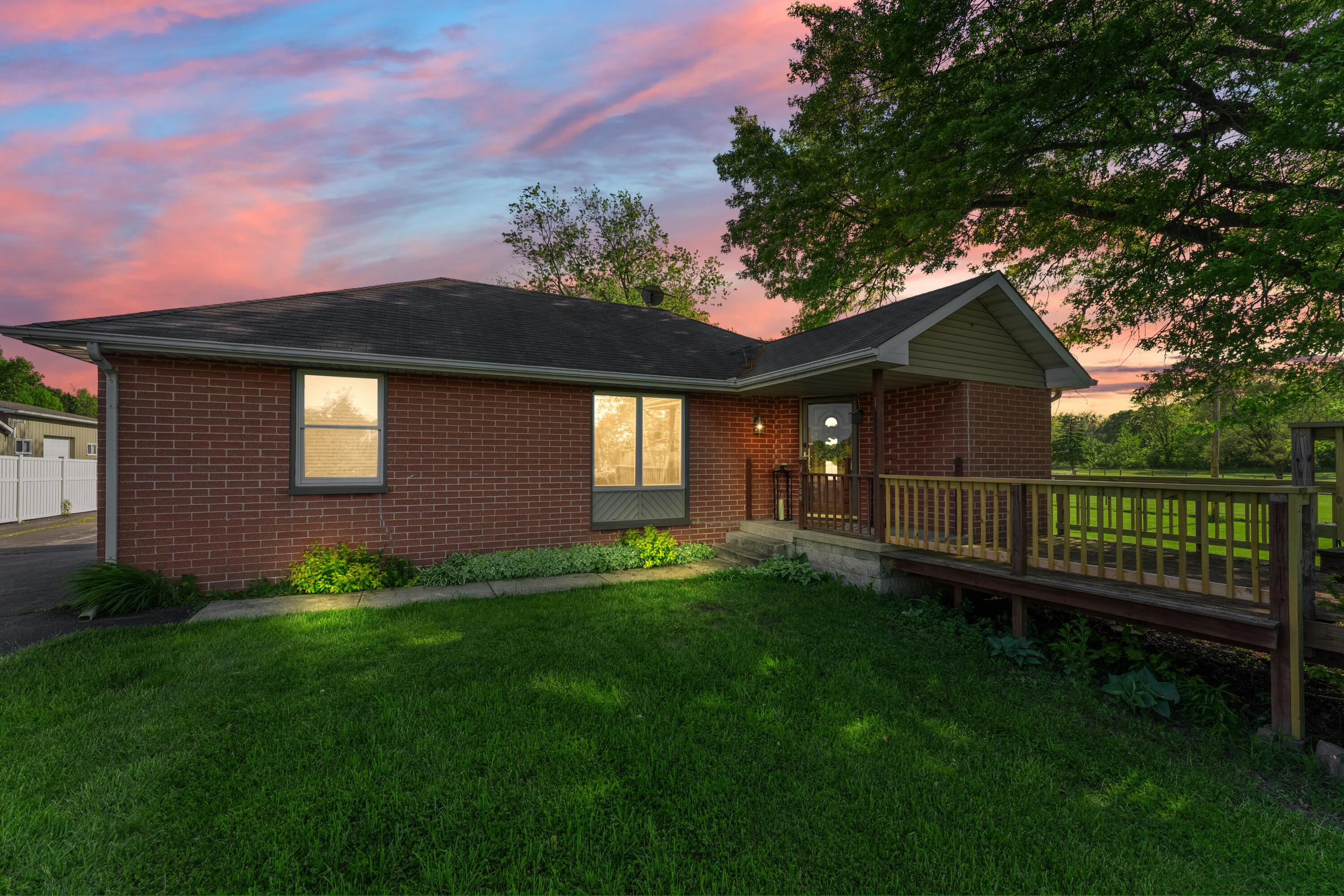 a view of a house with a yard and wooden fence