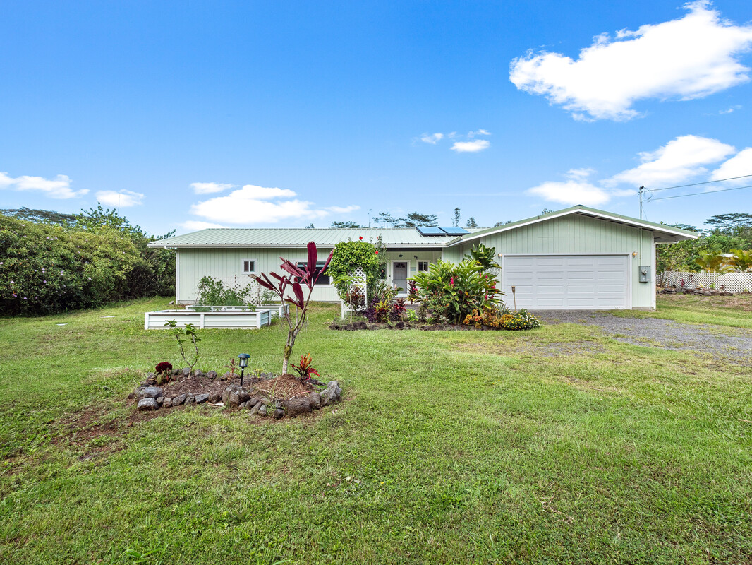 a view of a house with a yard and a garden