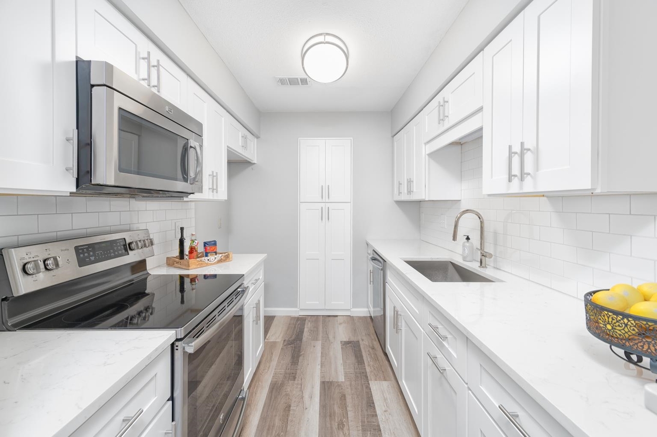 a kitchen with a sink a stove and cabinets