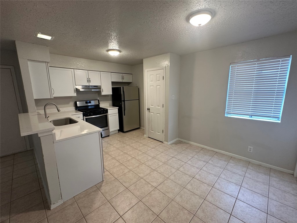 a view of kitchen and refrigerator