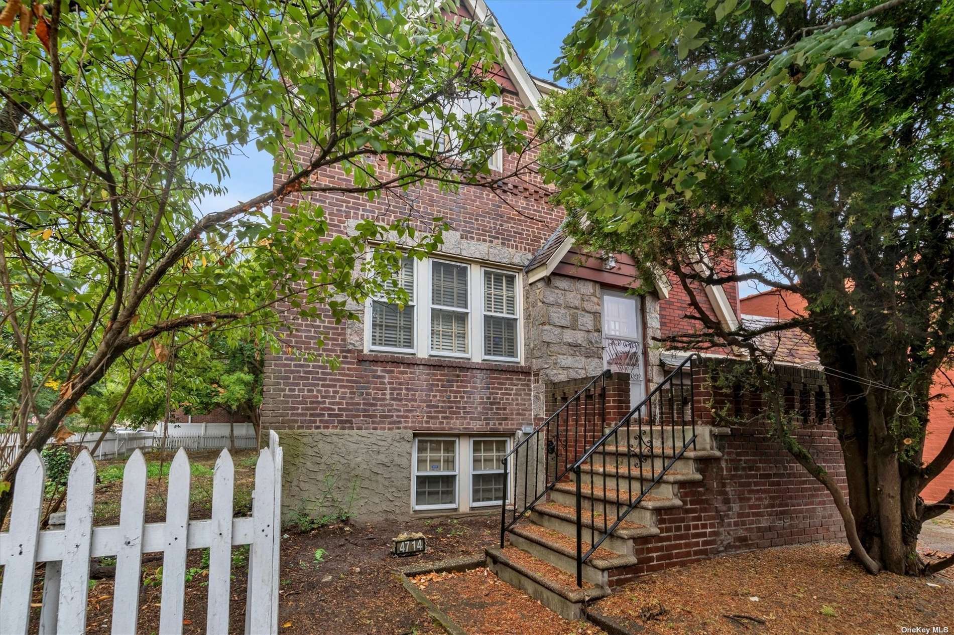 a front view of a house with deck and trees