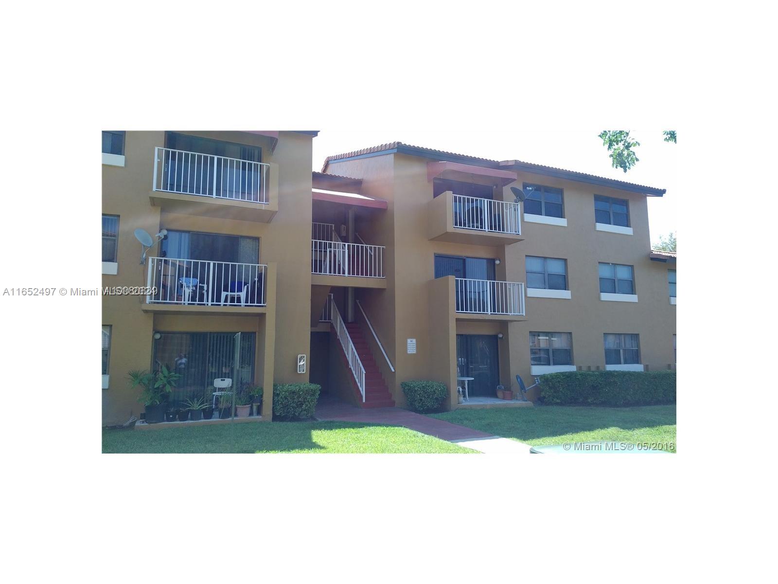 a front view of a residential apartment building with a yard