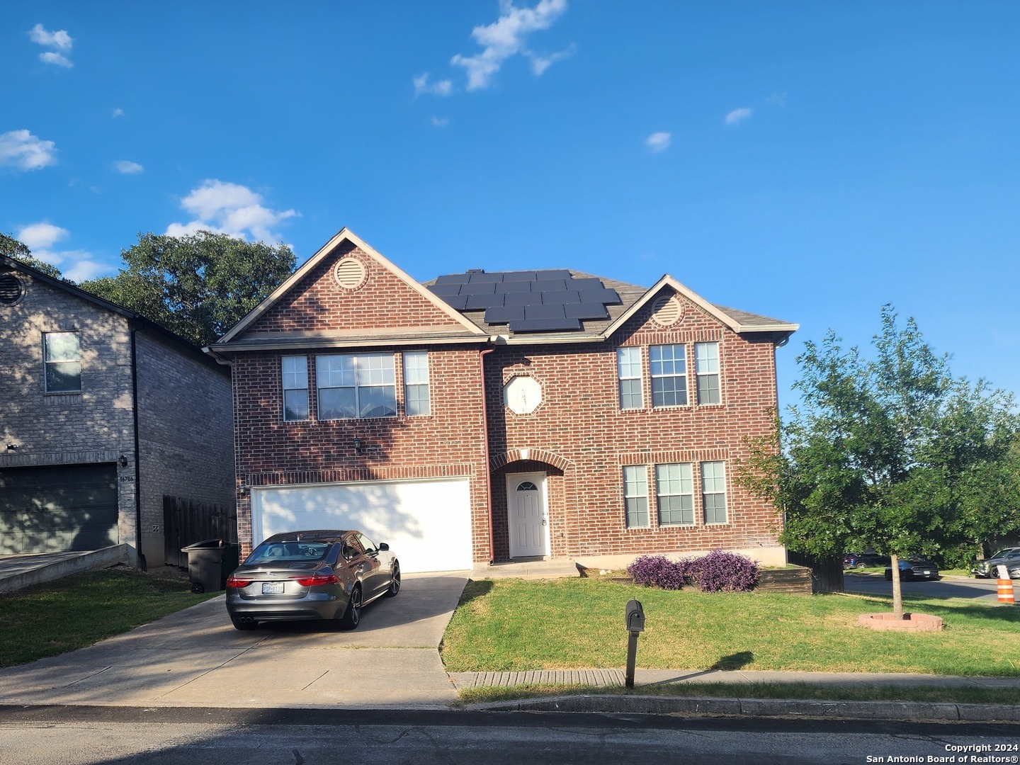 a view of a car parked in front of a brick house