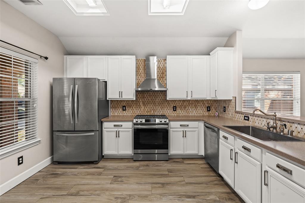 a kitchen with a white cabinets and stainless steel appliances