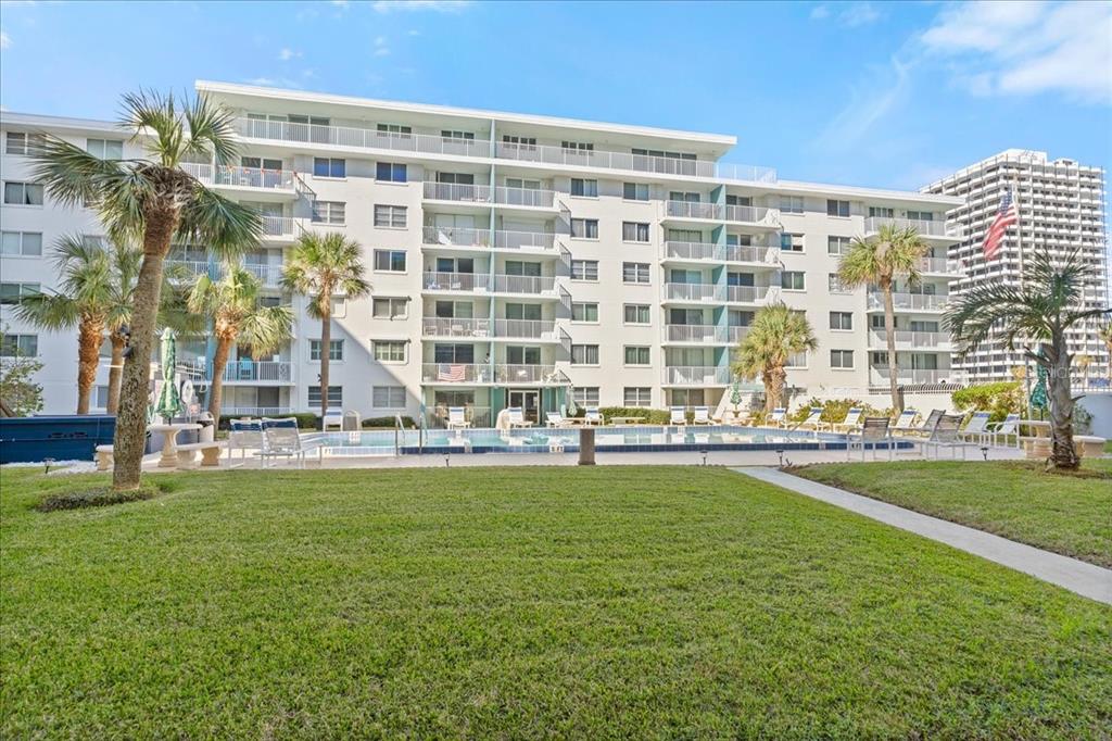 a large building with swimming pool in front of it