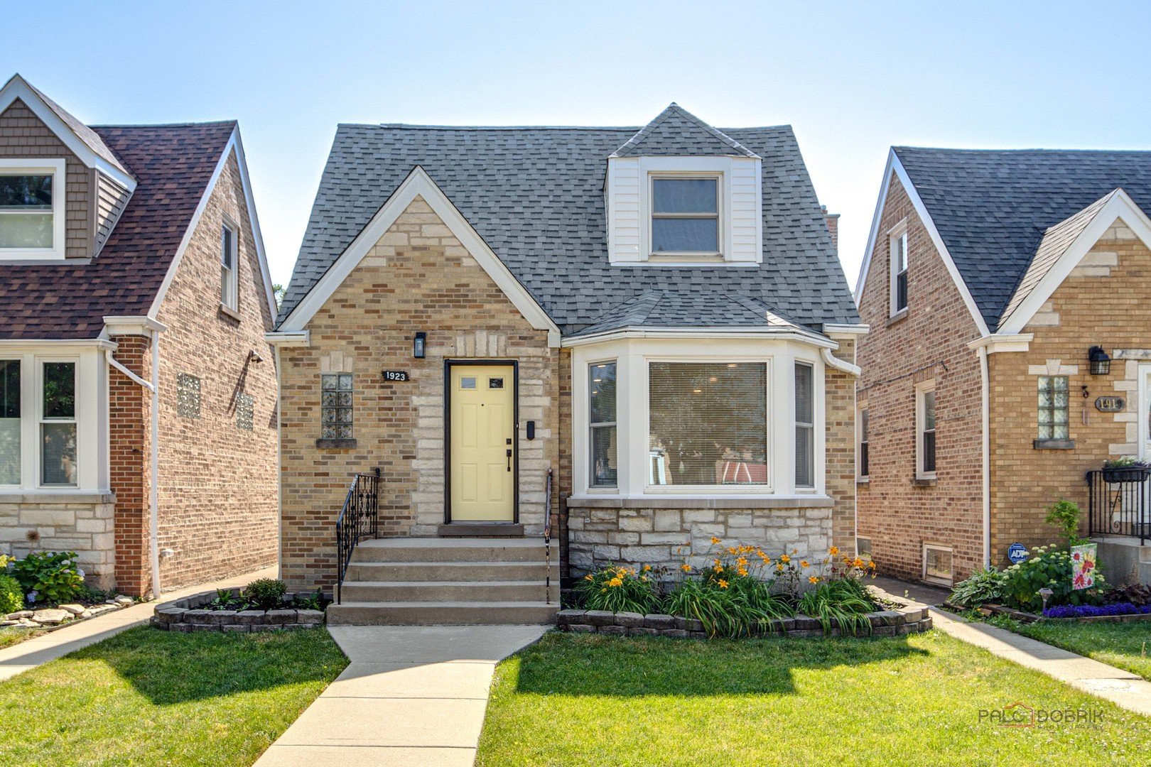 a view of a brick house with windows and yard