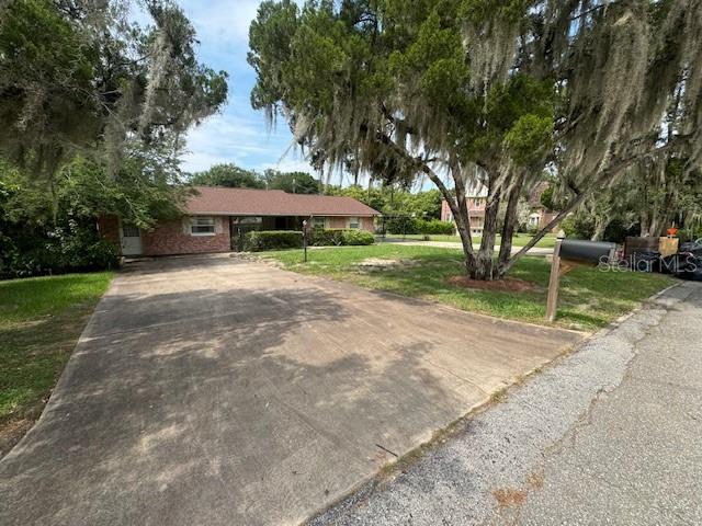 a view of a house with a yard and tree s