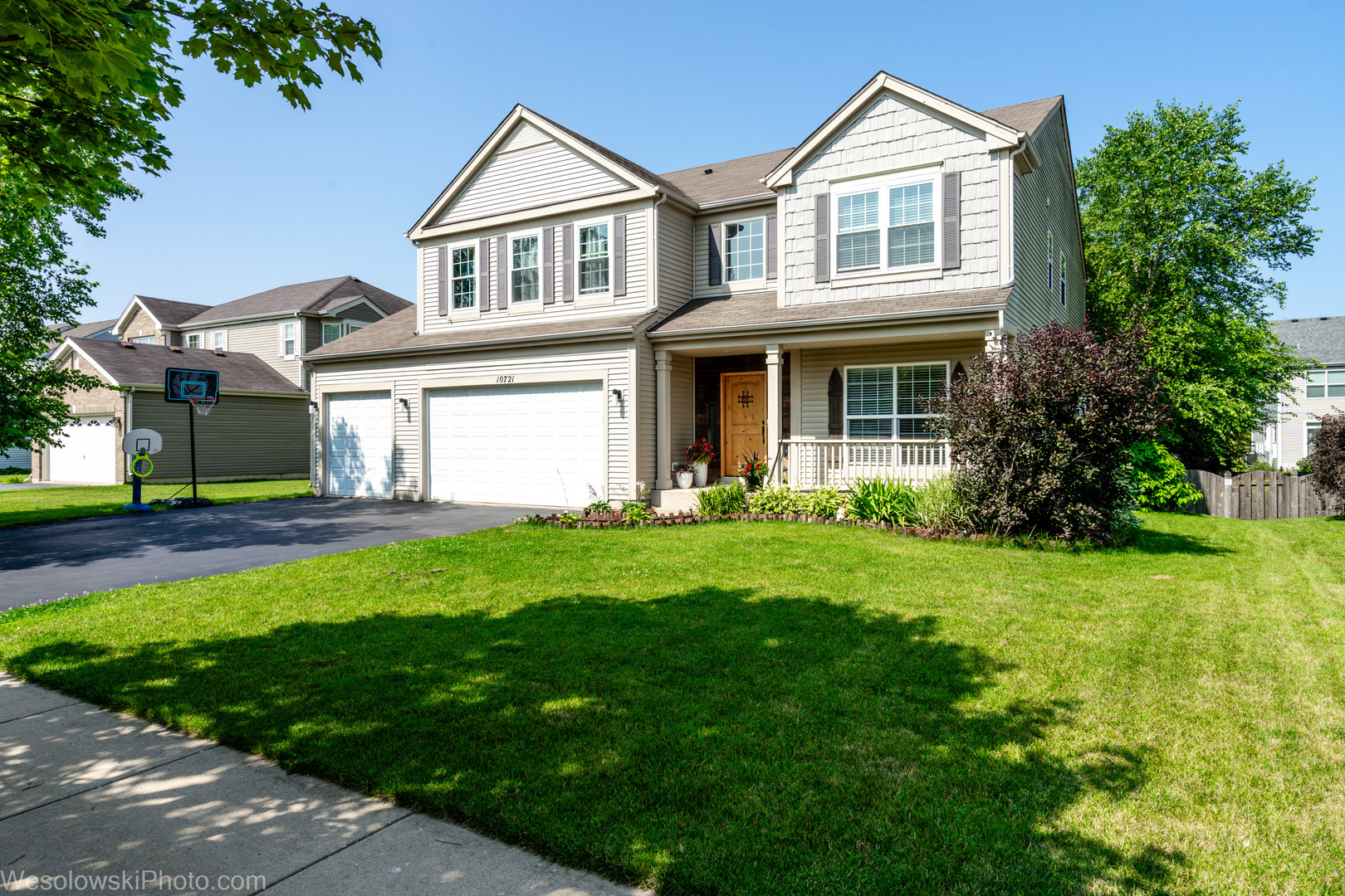 a front view of a house with a yard and trees