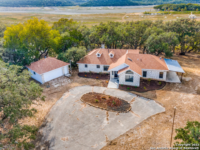 a front view of a house with a yard and lake view