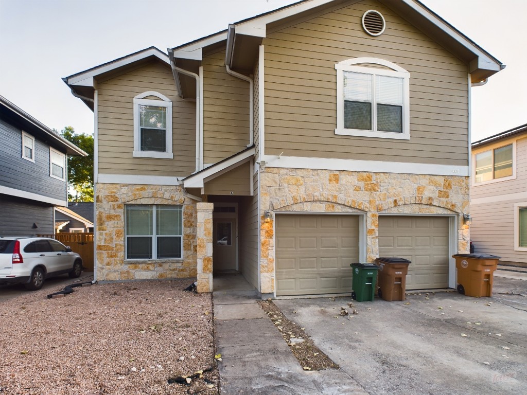 a view of a house with a yard and parking space