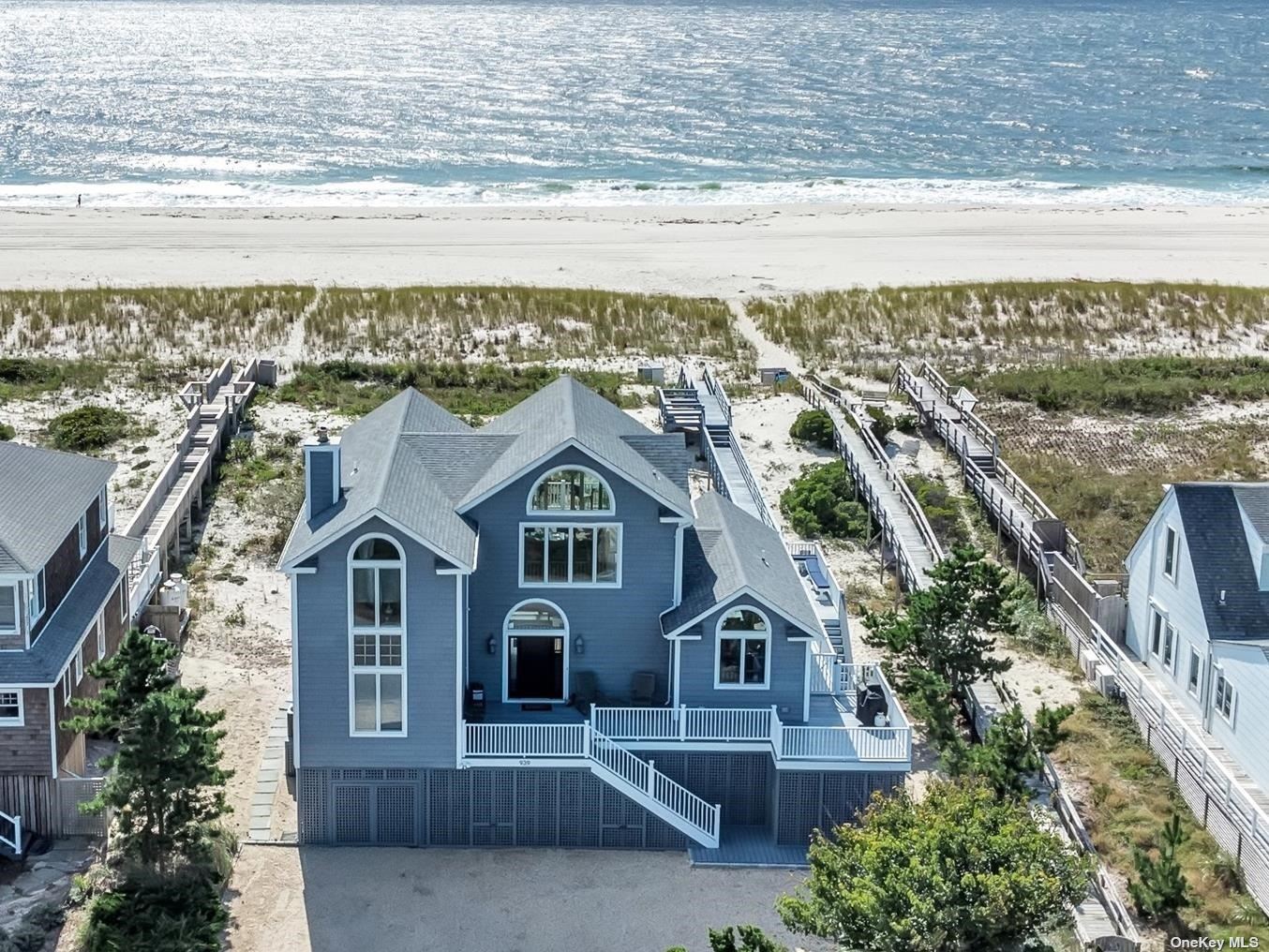 an aerial view of residential houses with outdoor space and ocean