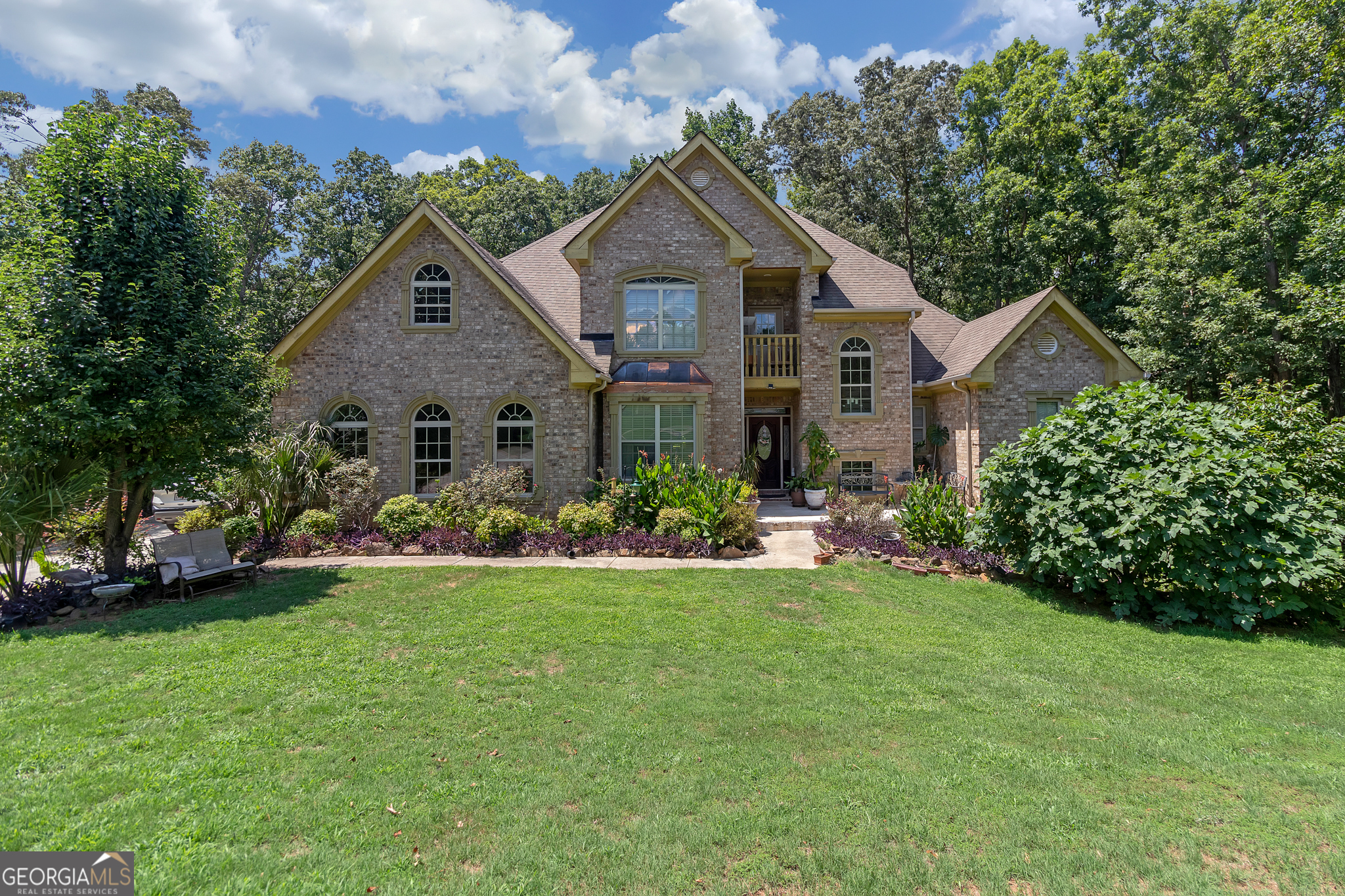 a front view of a house with a yard and trees