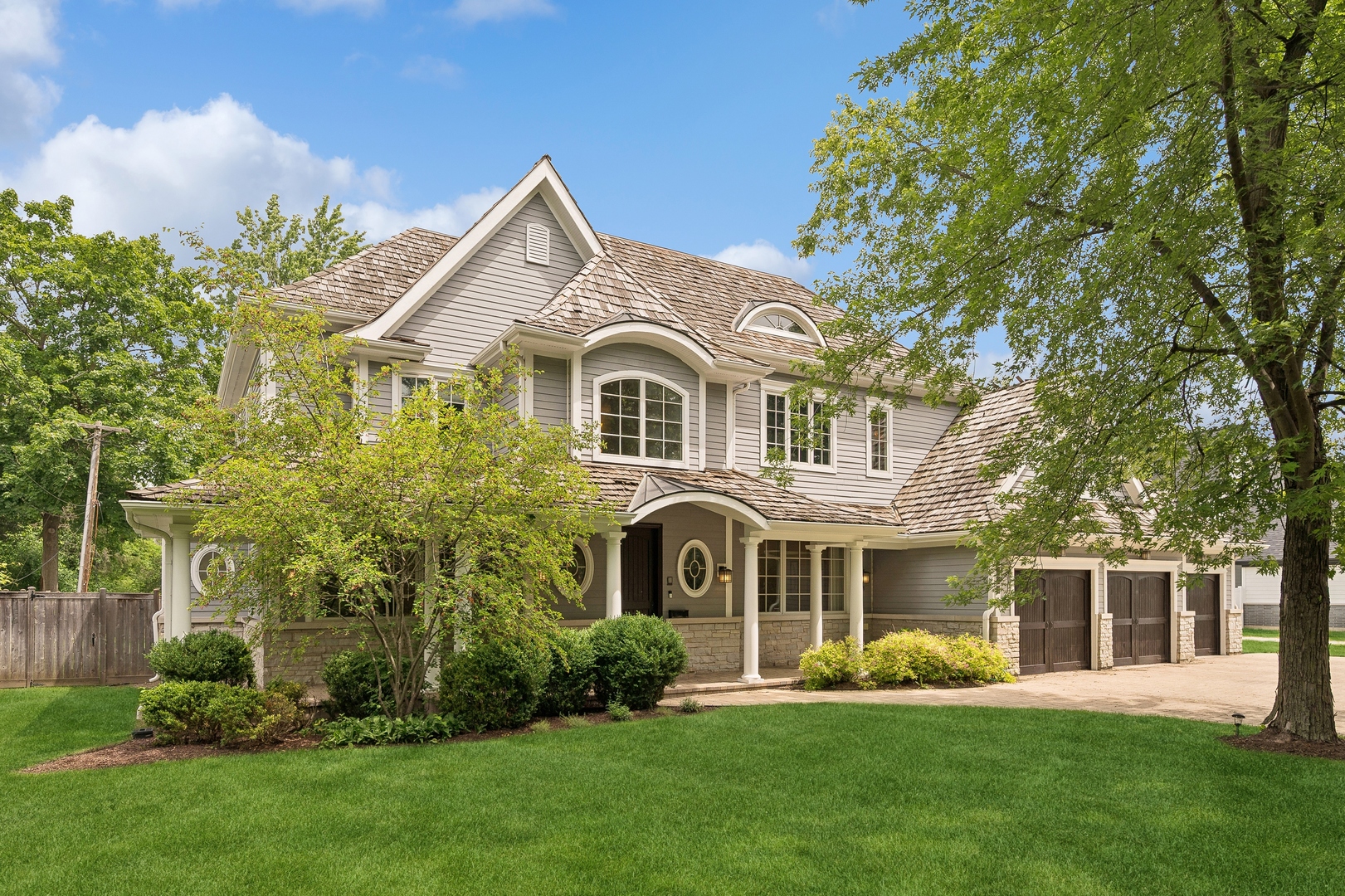 a front view of a house with a garden and trees