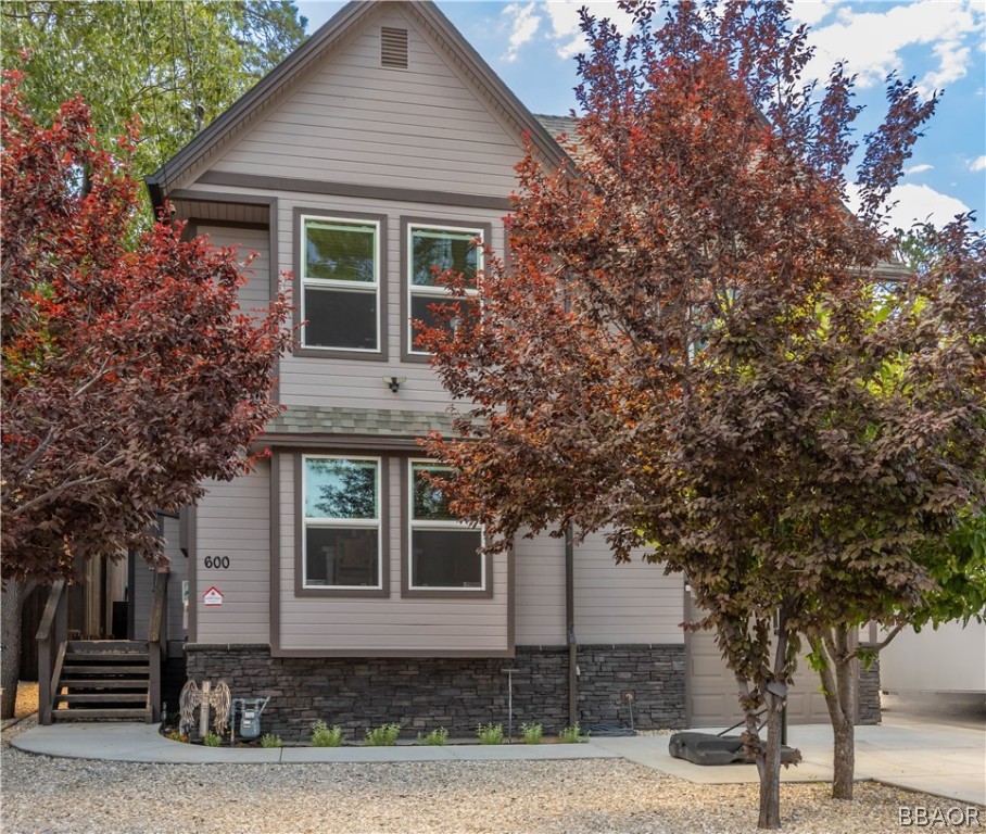 a front view of a house with a tree